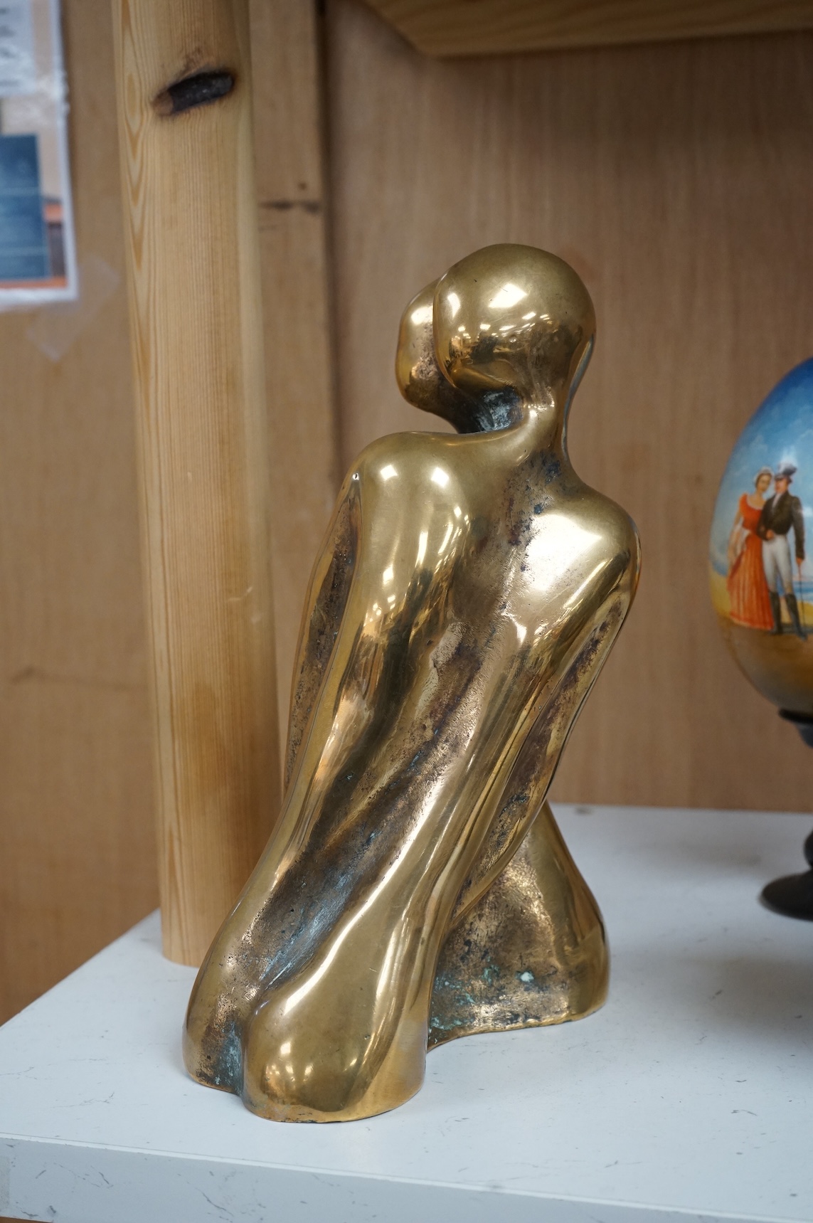 A modernist polished bronze sculpture, two entwined figures, indistinctly signed, 23cm high